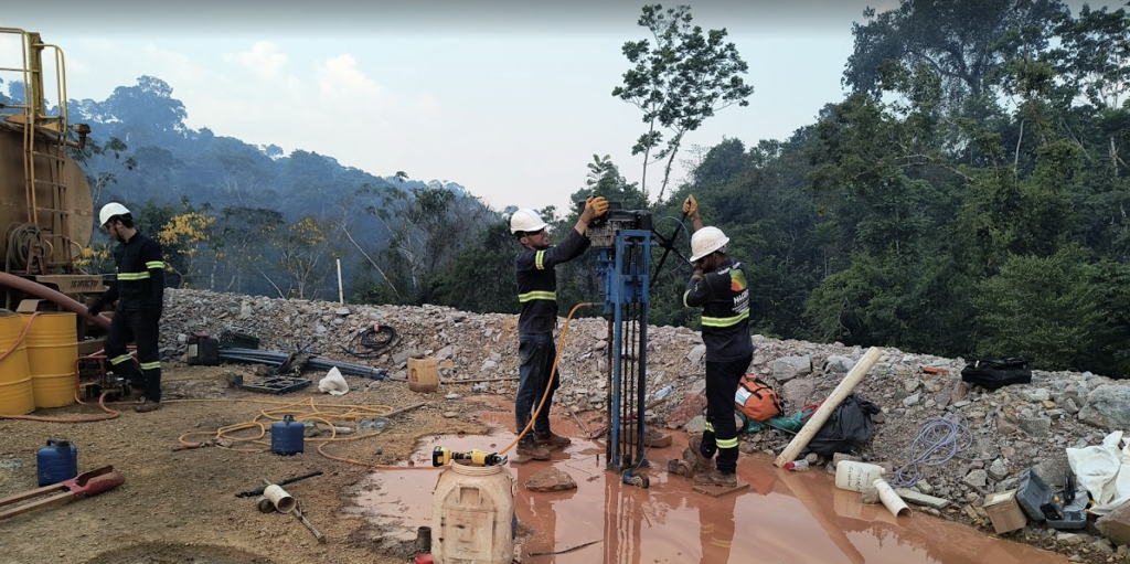 Equipe executando sondagem rotativa em área de mineração